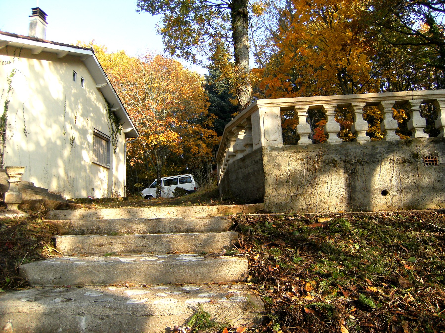 Façade de la maison de 1960 et sa balustrade de pierre en automne — maison à vendre avec étang et forêt en Charente